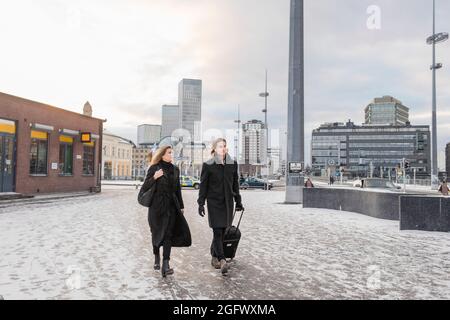 Frau und Mann mit Koffer laufen durch die Stadt Stockfoto
