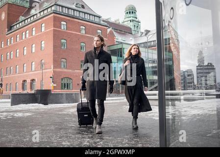 Frau und Mann mit Koffer laufen durch die Stadt Stockfoto