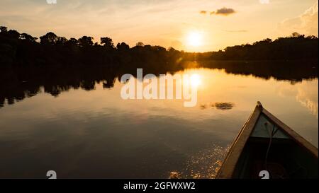 Amazonien. Blick auf den Sonnenuntergang vom Holzboot aus. Jaguar (Onza) Lagune in der Nähe des Javari River, dem Nebenfluss des Amazonas. Selva an der Grenze von Stockfoto