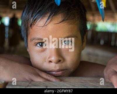 Iquitos, Peru - Dezember 2019: Junge vom Stamm der Yaguas am Eingang der maloka - ein Bewohner Perus. Nativa Yagua Comunidad. Amazonien, Lati Stockfoto