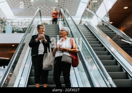 Ältere Frauen stehen auf der Rolltreppe Stockfoto