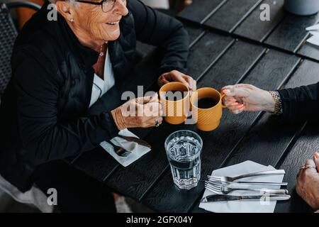 Ältere Frau, die im Café im Freien sitzt Stockfoto