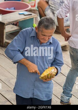 Caballococha, Peru - Dec 11, 2017: Porträt eines Mannes essen Ananas vom Löffel. Stockfoto