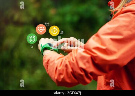 Sporttechnologie - Frau, die Fitness-Tracker verwendet, um Gesundheit und Bewegung beim Outdoor-Training zu verfolgen Stockfoto