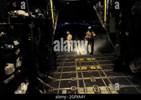 Senior Airman Michael Schoettlin, links, und Staff Sgt. Mary Sierra, beide HC-130P „Combat King“ Hercules Lademeister, die zur 79. Expeditionary Rescue Squadron eingesetzt wurden, warten am 10. April auf dem Kandahar Airfield, Afghanistan, auf die Lieferung von medizinischem Material an das Flugzeug. Stockfoto