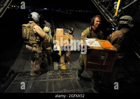 Eine HC-130P Herkules-Besatzung, die der 79. Expeditionary Rescue Squadron zugewiesen wurde, beladen am 10. April im Kandahar Airfield, Afghanistan, Kartons mit medizinischen Hilfsgütern. Stockfoto