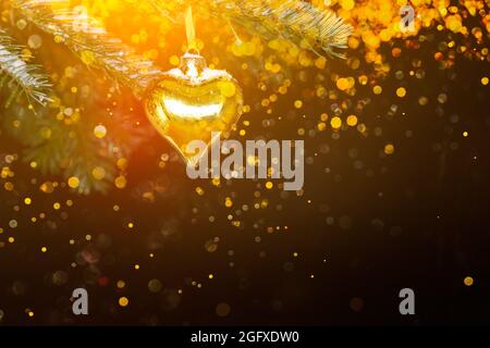 Goldene weihnachtsschmuck, Herzform, auf schwarzem Hintergrund, mit vielen magischen goldenen Funkeln, Copyspace. Stockfoto