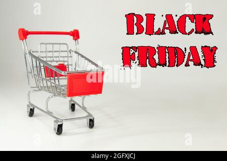 Schwarzer Freitag, 2021. Design für Black Friday, begleitet von einem Metalleinkaufwagen für die riesigen Verkäufe an diesen Terminen. Weißer Hintergrund. Platz für Text. Stockfoto