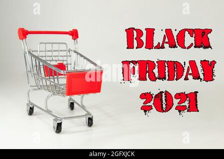 Schwarzer Freitag, 2021. Design für Black Friday, begleitet von einem Metalleinkaufwagen für die riesigen Verkäufe an diesen Terminen. Weißer Hintergrund. Platz für Text. Stockfoto