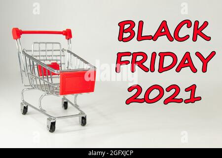 Schwarzer Freitag, 2021. Design für Black Friday, begleitet von einem Metalleinkaufwagen für die riesigen Verkäufe an diesen Terminen. Weißer Hintergrund. Platz für Text. Stockfoto