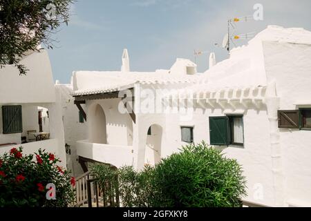 Blick auf die Gassen und weißen Architektur und Gebäude des Fischerdorfes Binibeca Vell, Menorca, Spanien während der Sommersaison. Stockfoto