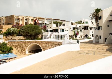 Blick auf die Gassen und weißen Architektur und Gebäude des Fischerdorfes Binibeca Vell, Menorca, Spanien während der Sommersaison. Stockfoto