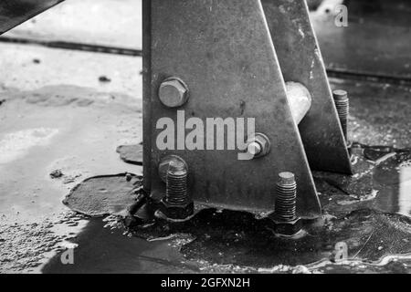 Abstrakte industrielle nassgraue Metallstrukturen, verbunden mit Schrauben, Nahaufnahme in Schwarzweiß mit selektivem Weichfokus Stockfoto