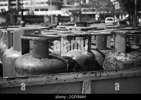 Haushalts-Gasflaschen mit Propan steht in einer Reihe, schwarz-weiß Foto Stockfoto