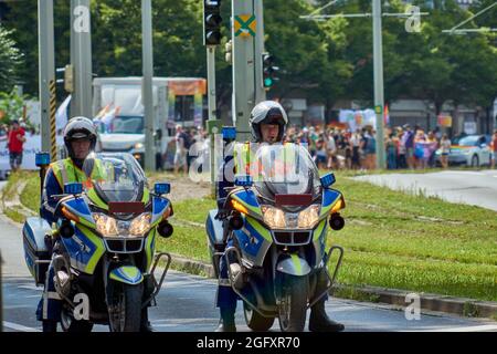 Braunschweig, 14. August 2021: Zwei Polizisten fahren vor einer großen Gruppe mit Demonstranten auf dem CSD auf dem Motorrad Stockfoto