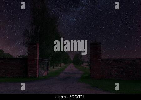 Tor und Zufahrtsstraße zur Residenz in der Nacht, in Dunkelheit gehüllt. Stockfoto