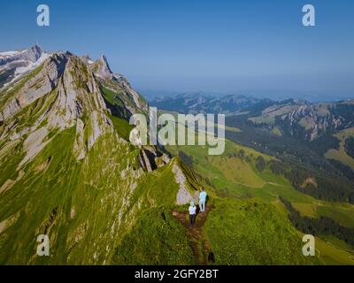 Eine Frau mit Rucksack steht auf einem Berg, das Mädchen reist an schöne Orte und erreicht das Ziel, Bergrücken bei Saxer Lucke, Kreuzberg in Alpstein Appenzell Innerrhoden Schweiz. Stockfoto