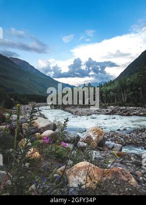 Vertikale abstrakte Landschaft mit Bergen und Fluss, ein perfekter Ort für Urlaub. Sommerliche Reisefotografie, Wander- oder Laufreiseplanung Stockfoto