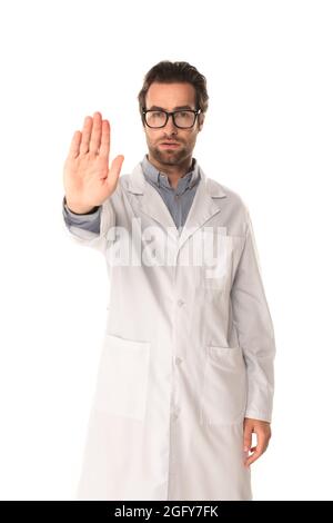 Junger Arzt zeigt Stoppgeste isoliert auf Weiß Stockfoto