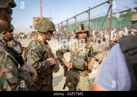 US Marine Brig. General Farrell J. Sullivan, der Kommandeur der Marine Amphibious Task Force 51/5th Marine Expeditionary Brigade, spricht während einer Evakuierung am Hamid Karzai International Airport, Kabul, Afghanistan, am 24. August mit einem Dienstmitglied der italienischen Koalitionstruppe. US-Dienstmitglieder und Koalitionsstreitkräfte unterstützen das Außenministerium bei einer nicht-kämpferischen Evakuierungsoperation (NEO) in Afghanistan. (USA Marine Corps Foto von Staff Sgt. Victor Mancilla) Stockfoto