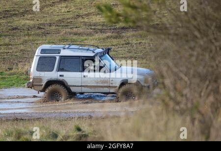 4x4 Land Rover Discovery Serie II off roading, waten in tiefem Wasser und rutschigem Schlamm Stockfoto