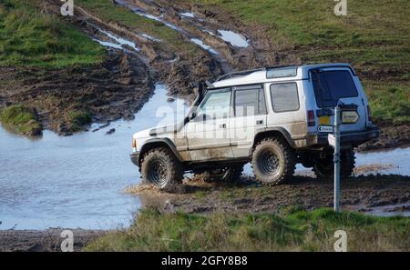 4x4 Land Rover Discovery Serie II off roading, waten in tiefem Wasser und rutschigem Schlamm Stockfoto