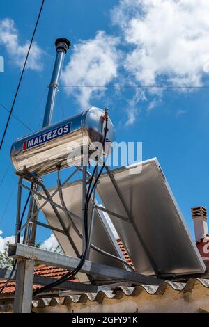 Solarheizungsbehälter, Sonnenkollektoren auf griechischem Haus, globale Erwärmung, Klimawandel, Solarenergie, häusliche Solarenergie, Solarbetriebener Warmwasserbereiter griechenland. Stockfoto