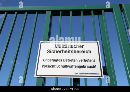 Wunstorf, Deutschland. August 2021. Ein Schild mit der Aufschrift „Military Security Area - No Trespassing! Achtung - Verwendung von Schusswaffen! Vor der Ankunft von drei Flugzeugen der Bundeswehr aus der Evakuierungsmission aus Afghanistan am Stützpunkt im niedersächsischen Wunstorf hängt es am Flughafen an einem Zaun. Quelle: Friso Gentsch/dpa/Alamy Live News Stockfoto