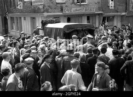 Die Befreiung von Honfleur, Normandie, Frankreich während des zweiten Weltkrieges. 27. August 1944. Die Einheimischen beobachten, wie britische Soldaten nach ihrer Kapitulation junge deutsche Soldaten wegnehmen. Stockfoto