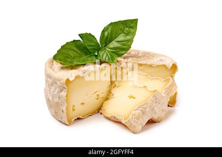 Delicatessen Weichkäse mit Basilikumblättern isoliert auf weißem Hintergrund Stockfoto