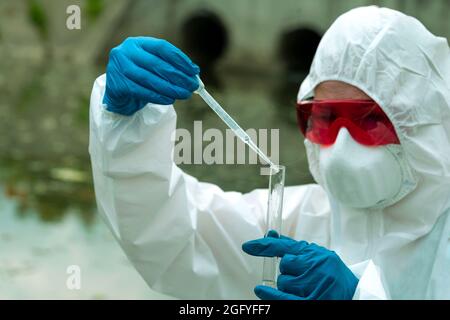 Probenahme aus offenem Wasser. Ein Wissenschaftler oder Biologe nimmt eine Wasserprobe. Wasserprobe in einem chemischen Reagenzglas mit einer Pipette Stockfoto