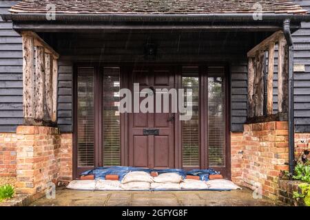 Sandsäcke neben einem Haus, um Hochwasserschäden zu vermeiden, Barcombe Mills, East Sussex, Großbritannien Stockfoto