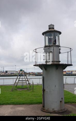 Zeebrugge Port, Belgien - 6. August 2021: Historischer grauer Metalllichtsignalturm auf dem Display entlang der Paardenmarktstraat mit Containerterminal in der Rückseite U Stockfoto