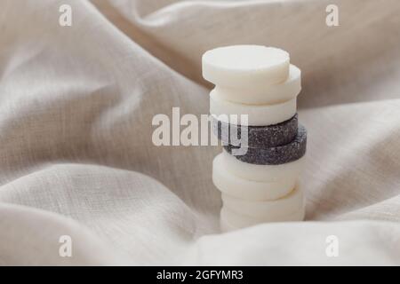 Stapel von verschiedenen natürlichen Seifenstücken mit Lavendel auf Leinentextilien. Pastellfarben Stockfoto