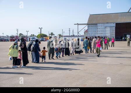 Rota, Spanien. August 2021. Matrosen der US-Marine unterstützen afghanische Flüchtlinge, die von Kabul bei der Ankunft auf der Marinestation Rota am 27. August 2021 in Rota, Spanien, evakuiert wurden. NS Rota stellt im Rahmen der Operation Allies Refuge eine vorübergehende Unterkunft für Evakuierte aus Afghanistan bereit. Quelle: Planetpix/Alamy Live News Stockfoto