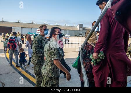 Rota, Spanien. August 2021. Matrosen der US-Marine unterstützen afghanische Flüchtlinge, die von Kabul bei der Ankunft auf der Marinestation Rota am 27. August 2021 in Rota, Spanien, evakuiert wurden. NS Rota stellt im Rahmen der Operation Allies Refuge eine vorübergehende Unterkunft für Evakuierte aus Afghanistan bereit. Quelle: Planetpix/Alamy Live News Stockfoto