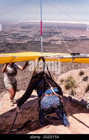 Ein Drachenflieger-Pilot bereitet sich auf den Start von der Startrampe auf Horse Ridge im Dry Canyon in der Nähe von Alamogordo, New Mexico, vor. In der Ferne ist weißer Sand Stockfoto