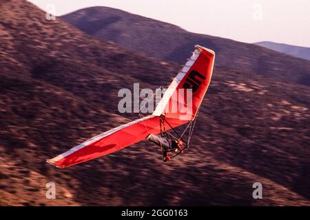 Ein Drachenflieger macht einen Hochgeschwindigkeitspass, während er über den Dry Canyon in der Nähe von Alamogordo, New Mexico, fliegt. Stockfoto