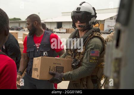 Port Au Prince, Haiti. August 2021. Matrosen der US-Marine und USAID-Arbeiter laden während einer humanitären Mission am 25. August 2021 in Port-Au-Prince, Haiti, Lebensmittel ein. Das Militär unterstützt die Folgen des jüngsten Erdbebens. Quelle: Planetpix/Alamy Live News Stockfoto