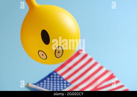 Gelbe Emoji-Ballons mit amerikanischen Flaggen auf blauem Hintergrund. Geburtstag des Emoticons. Stockfoto