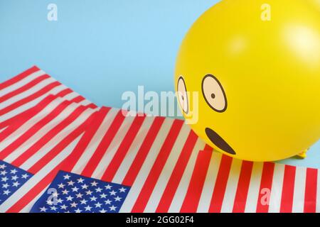 Gelbe Emoji-Ballons mit amerikanischen Flaggen auf blauem Hintergrund. Geburtstag des Emoticons. Stockfoto