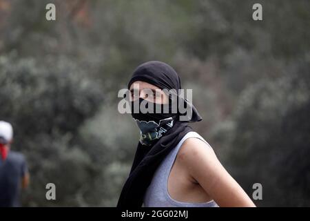 Nablus, Palästina. August 2021. Ein maskierter Palästinenser schaut während der Demonstration gegen den israelischen Außenposten Eviatar im Dorf Beita in der Nähe der Stadt Nablus im Westjordanland zu. (Foto von Nasser Ishtayeh/SOPA Images/Sipa USA) Quelle: SIPA USA/Alamy Live News Stockfoto