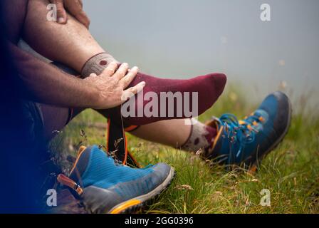 Nahaufnahme von Wanderfüßen in Socken ohne Schuhe, die auf dem Berggipfel ruhen Stockfoto