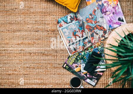 Lesen von Comic-Büchern und Manga auf dem Teppich bei Cosy Home. Stockfoto