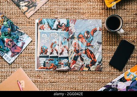 Lesen von Comic-Büchern und Manga auf dem Teppich bei Cosy Home. Stockfoto