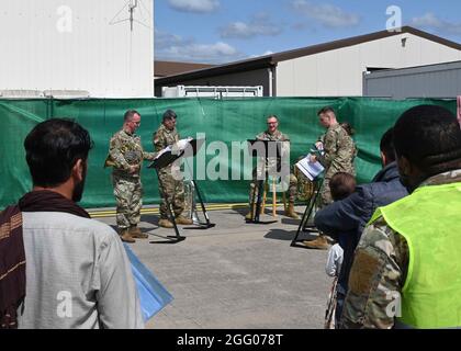 Ramstein Miesenbach, Deutschland. August 2021. Afghanische Flüchtlinge hören Musik von der US Army Europe und Africa Band im Flüchtlingslager am Ramstein Air Base am 22. August 2021 in Ramstein-Miesenbach. Der Luftwaffenstützpunkt Ramstein stellt im Rahmen der Operation Allies Refuge vorübergehend Unterkunft für Evakuierte aus Afghanistan bereit. Quelle: Planetpix/Alamy Live News Stockfoto