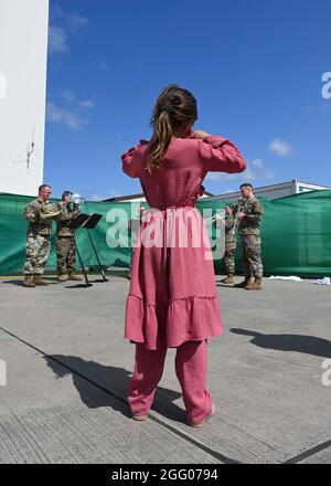 Ramstein Miesenbach, Deutschland. August 2021. Ein afghanisches Kind hört der U.S. Army Europe and Africa Band Musik zur Unterhaltung von Flüchtlingen auf dem Ramstein Air Base am 22. August 2021 in Ramstein-Miesenbach, Deutschland. Der Luftwaffenstützpunkt Ramstein stellt im Rahmen der Operation Allies Refuge vorübergehend Unterkunft für Evakuierte aus Afghanistan bereit. Quelle: Planetpix/Alamy Live News Stockfoto