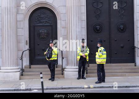 London, Großbritannien. August 2021. Extinction Rebellion (XR) und Rebellion von Tieren Protestierende besuchen den Londoner Finanzdistrikt , Quadratmeile, bis in die Nacht, besetzen die Landhauskreuzung von Queen Victoria Street und Cannon Street, bis zur Bank of England, Gegen den globalen Klimawandel. Klettern Sie auf Holzkonstruktionen, die mitten auf der Straße errichtet wurden. Um gegen Investitionen in fossile Brennstoffe zu protestieren. Polizeibeamte schützen die Bank von England am Eingang zum Bankgebäude. Quelle: Xiu Bao/Alamy Live News Stockfoto