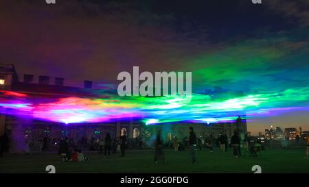 Greenwich, London, Großbritannien. August 2021. Die Menschen beobachten das Spektakel. An seiner offiziellen öffentlichen Startnacht beleuchtet „Borealis“ von Dan Archer den Himmel über dem Old Royal Naval College im Royal Borough of Greenwich. „Borealis“ ist eine faszinierende Nachbildung der Nordlichter am Himmel. Es ist Teil des jährlichen Greenwich and Docklands Festivals, das vom 27. August bis 11. September 2021 stattfindet. Kredit: Imageplotter/Alamy Live Nachrichten Stockfoto