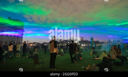 Greenwich, London, Großbritannien. August 2021. Die Menschen beobachten das Spektakel. An seiner offiziellen öffentlichen Startnacht beleuchtet „Borealis“ von Dan Archer den Himmel über dem Old Royal Naval College im Royal Borough of Greenwich. „Borealis“ ist eine faszinierende Nachbildung der Nordlichter am Himmel. Es ist Teil des jährlichen Greenwich and Docklands Festivals, das vom 27. August bis 11. September 2021 stattfindet. Kredit: Imageplotter/Alamy Live Nachrichten Stockfoto